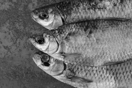 Dried fish. Salty dry river fish on a rusty metal plate background.の写真素材