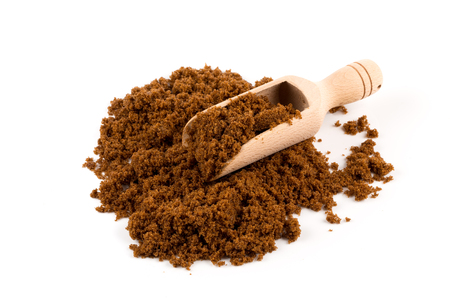 brown muscovado sugar in scoop isolated on white backgroundの写真素材
