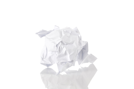 Crumbled paper ball trash close up over white backgroundの写真素材