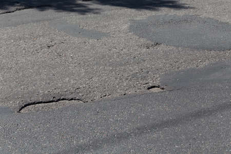 Urban road with damaged asphalt, from aboveの写真素材