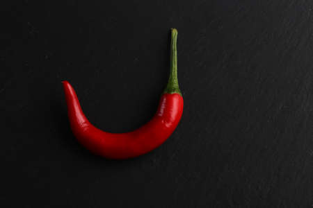 Red chili pepper on a dark stone backgroundの写真素材