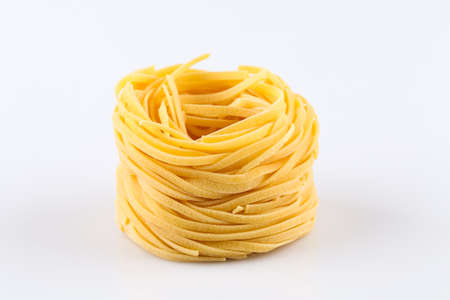Fettuccine pasta nest isolated on white backgroundの写真素材