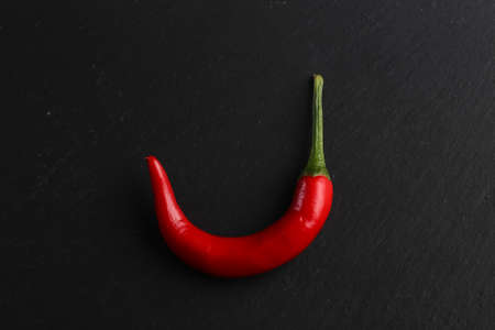Red chili pepper on a dark stone backgroundの写真素材