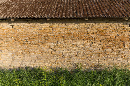 stone wall with grass foreground at sunsetの写真素材