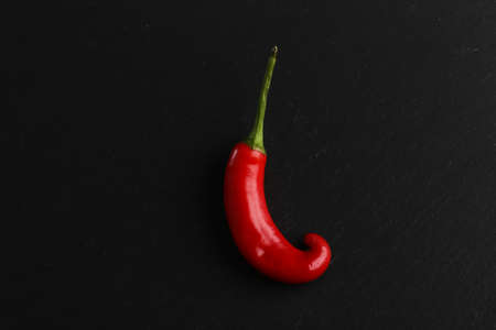 Red chili pepper on a dark stone backgroundの写真素材