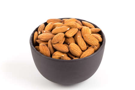 Black stone bowl of almonds nuts on a white backgroundの写真素材