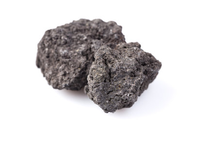 Black lava rock from volcano on a white backgroundの写真素材