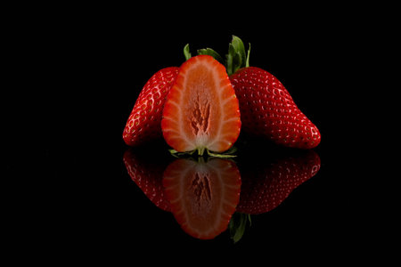 Red ripe strawberry fruits on a dark backgroundの写真素材