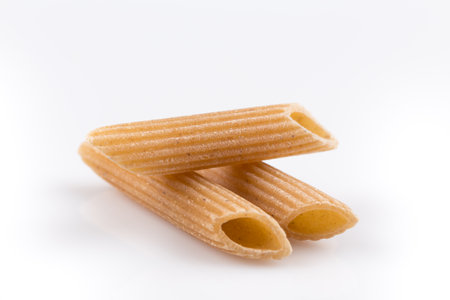 Wholemeal Pasta Penne as close-up shot isolated on white backgroundの写真素材