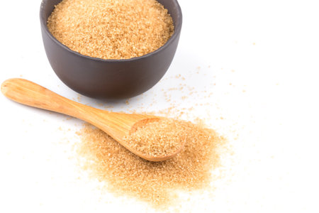 brown sugar in a wooden spoon on white backgroundの写真素材