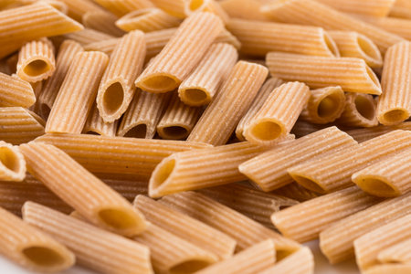 Wholemeal Pasta Penne as close-up shot for backgroundの写真素材