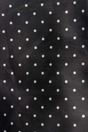 black fabric background with white dots
