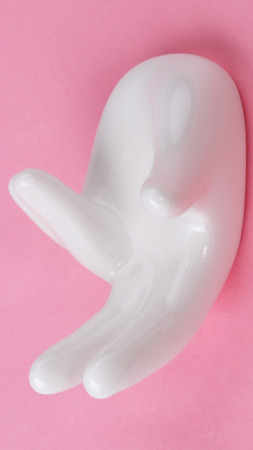 Ceramic stand with hand shape on pink backgroundの写真素材