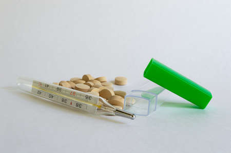 close-up shot of pills and medical mercury thermometers