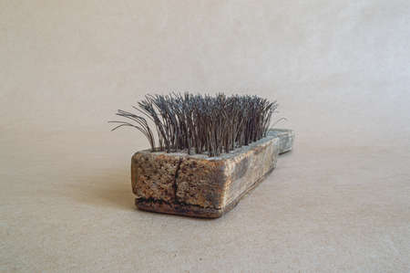 Vintage brush with metal bristles, isolated on paper background.