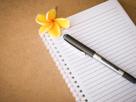 pen on notebook wooden background