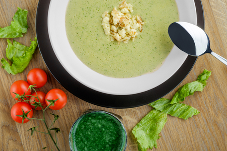 serving of cream soup with cherry tomatoesの写真素材