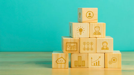 Wooden blocks with business icons on wooden table over blue background.