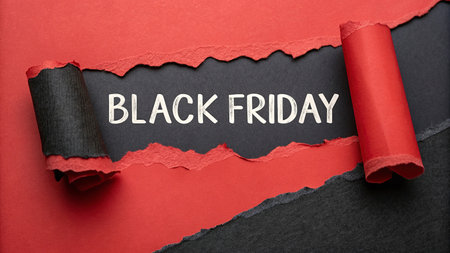 Black Friday concept. Red torn paper with black Friday text on black background.の写真素材