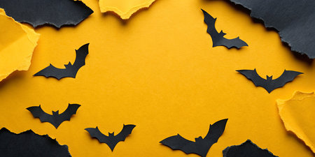 Halloween background with paper bats on yellow background. Top view.