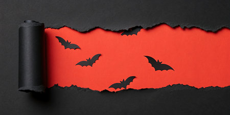 Halloween background with black bats and torn paper on red background.