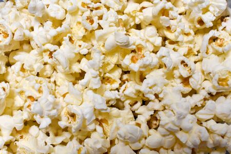 CLOSE UP OF A TRANSPARENT RECIPE FULL OF TASTY POPCORNS READY TO BE EATEN. CLASSICAL SALTY POPCORNS. HORIZONTAL PHOTOの写真素材