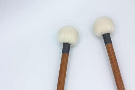 Crossed timpani mallets on a white background.