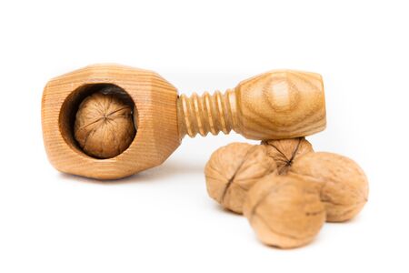Nutcraker and three walnuts isolated on white