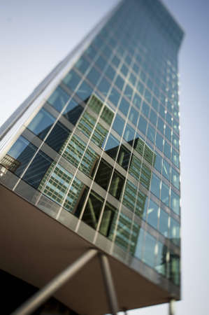 Green modern office building reflecting business district in glassのeditorial素材