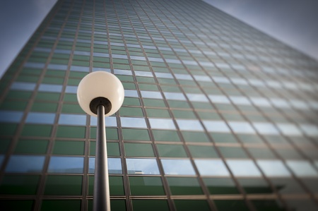 Lamp post in front of a green office building facadeの写真素材