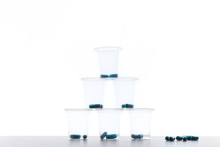 Capsule and pills medicines in plastic glass with white backlighting background close upの写真素材