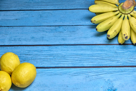 Freshly lemons and banana on rustic blue board backgroundの写真素材