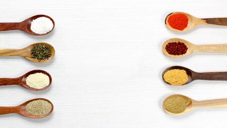 Assortment of spices in wooden spoons, white backgroundの写真素材