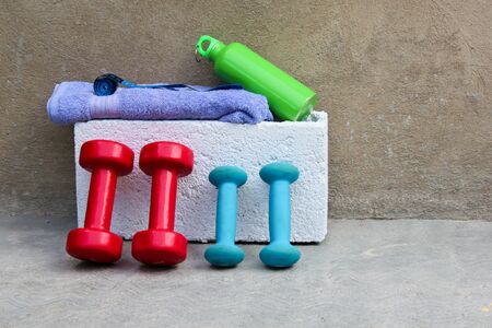 Fitness background. Dumbbells, towel and water on concrete backgroundの写真素材