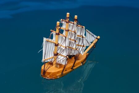 small toy boat in the water with big waves,
