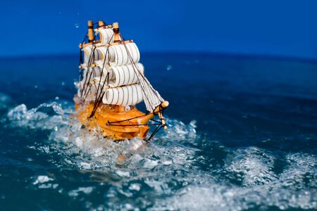 small toy boat in the water with big waves,
