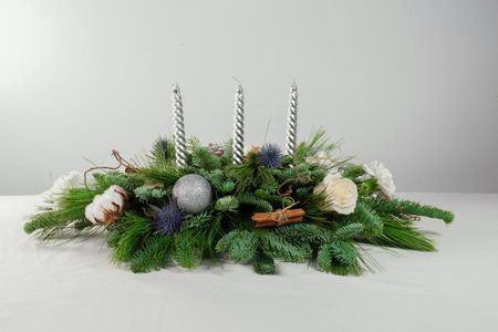 Christmas decoration with candles and evergreen branches on a white background.の写真素材