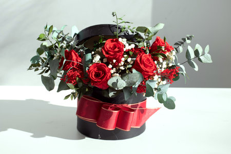 beautiful bouquet of red roses in black vase with red ribbonの写真素材