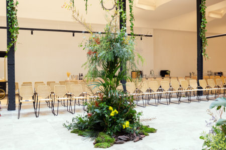 interior of a conference hall with chairs, tables and flowers.の写真素材