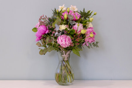 Bouquet of flowers in a glass vase on the tableの写真素材