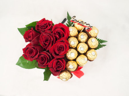Bouquet of red roses with chocolate candy on white background.の写真素材