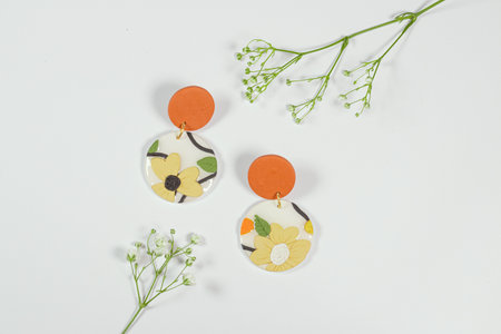 Earrings with flowers on white background. Flat lay, top view.の写真素材