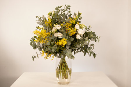 Bouquet of yellow and white flowers in a glass vaseの写真素材