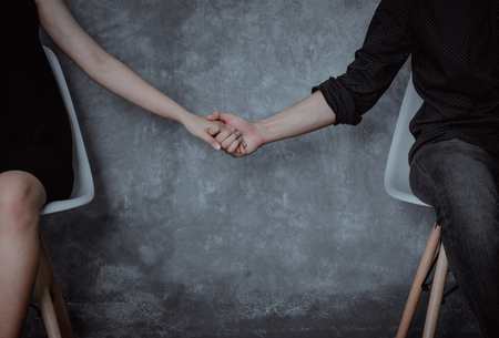 Young couples sitting chairs and holding hands than they have happiness in love and embrace with a sweet and romantic moments.の写真素材