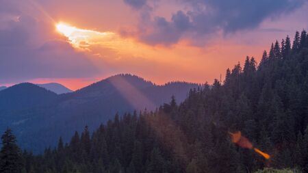 Sun with the rays in the sky of the Carpatian mountains before sunsetの写真素材