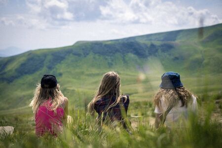 Three girls looking on the mountains in the Carpathians mountainsの写真素材