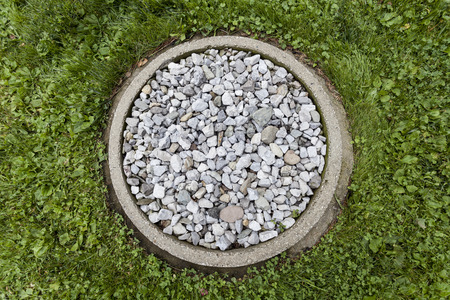 A ring of stones in the garden to catch the rain water from the drip rail