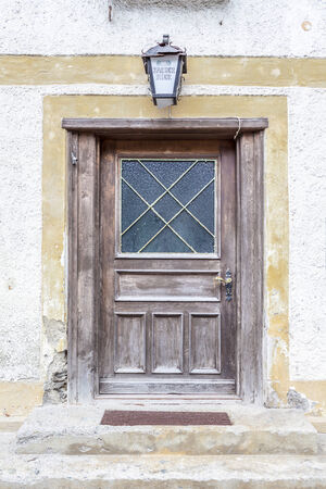 An old wooden door leading inside an old abandoned house.の写真素材
