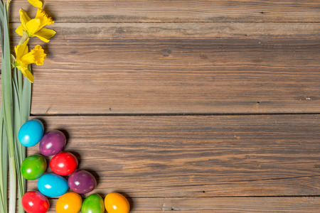 Easter eggs and flowers on a wooden tableの写真素材