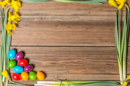 Easter eggs and flowers on a wooden tableの写真素材
